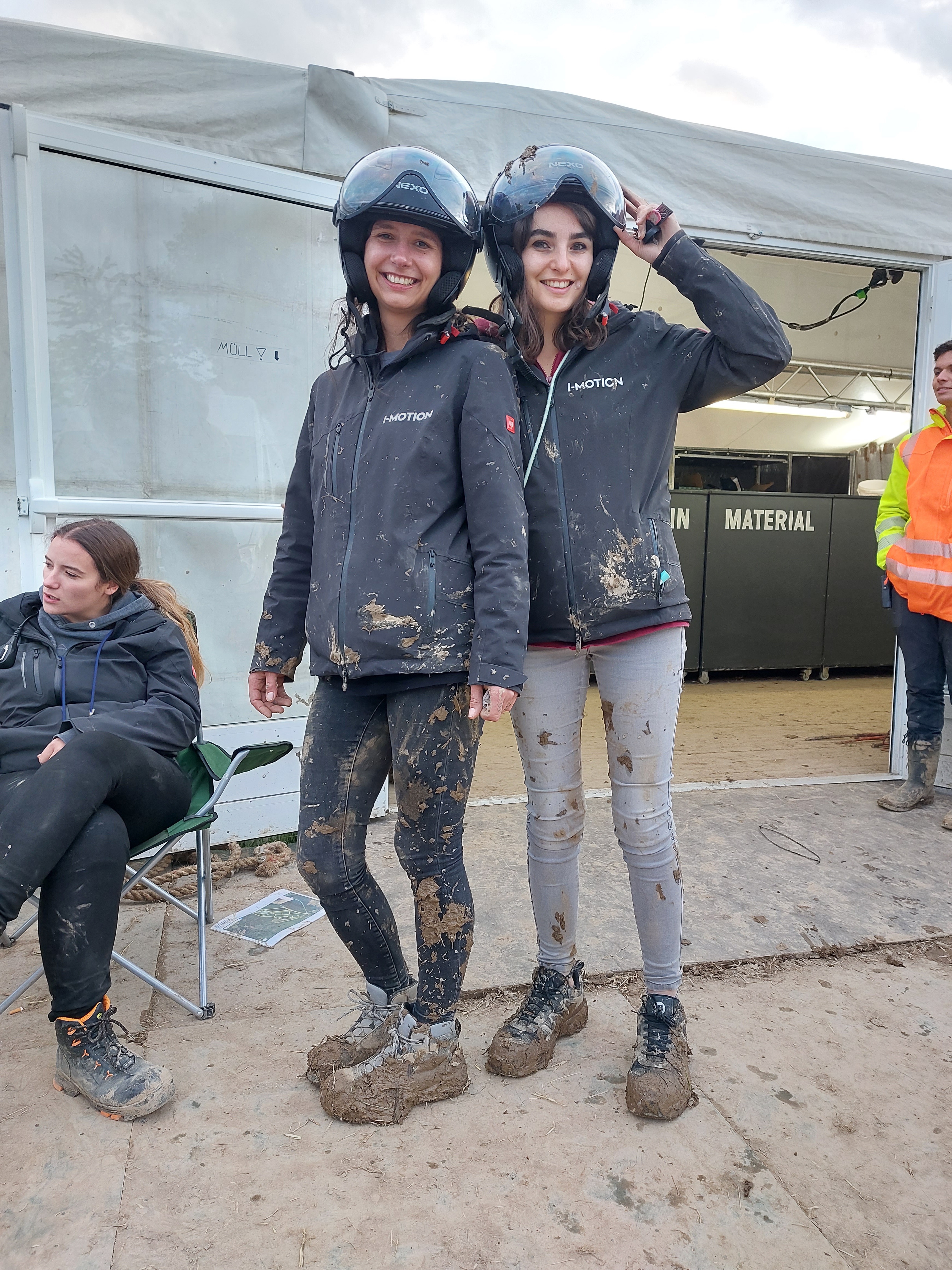 Zwei Teammitglieder mit Matsch an Kleidung und Schuhen